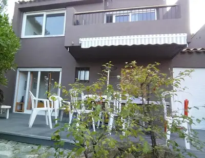 a house with a table and chairs in front of it at Villa La Viva Porticcio in Porticcio