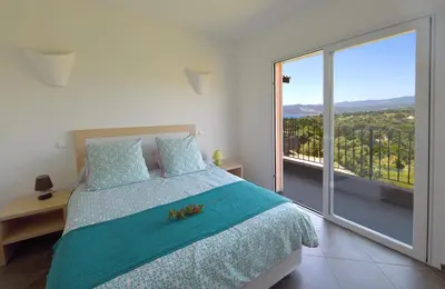 a bedroom with a bed and a large window at Valinco Locations OLMETO PLAGE in Olmeto
