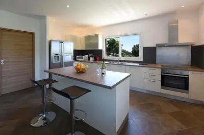 a kitchen with a island with a bowl of fruit on it at Valinco Locations OLMETO PLAGE in Olmeto