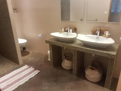 a bathroom with two sinks and a toilet at Valinco Locations OLMETO PLAGE in Olmeto