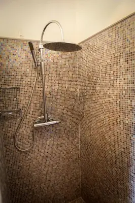 a shower with a shower head in a bathroom at Valinco Locations OLMETO PLAGE in Olmeto