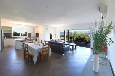 a kitchen and a living room with a table and chairs at Valinco Locations OLMETO PLAGE in Olmeto