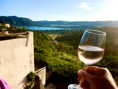a person holding a glass of white wine at Villa Bella Vista in Porto-Vecchio