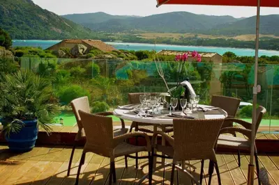 a table and chairs on a patio with a large window at Villa Bella Vista in Porto-Vecchio
