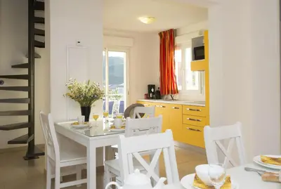 a kitchen and dining room with a table and chairs at Résidence Odalys Casa d'Orinaju in Oletta