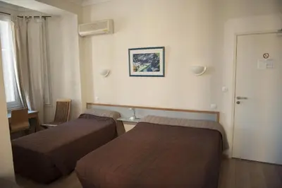 a hotel room with two beds in a room at Hotel du Palais in Ajaccio