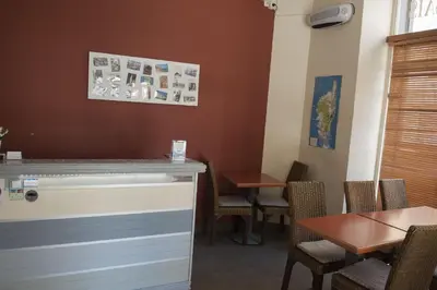 a restaurant with a counter and chairs and tables at Hotel du Palais in Ajaccio