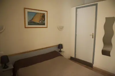 a bedroom with a bed and a picture on the wall at Hotel du Palais in Ajaccio