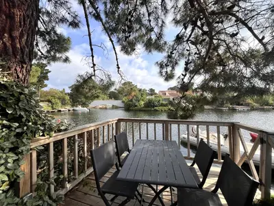 a table and chairs on a deck next to a river at San Ciprianu in Porto-Vecchio