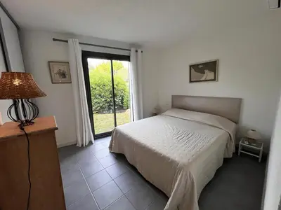 a bedroom with a bed and a large window at San Ciprianu in Porto-Vecchio