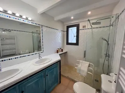 a bathroom with two sinks and a glass shower at San Ciprianu in Porto-Vecchio