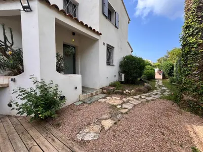 a white house with a walkway in front of it at San Ciprianu in Porto-Vecchio