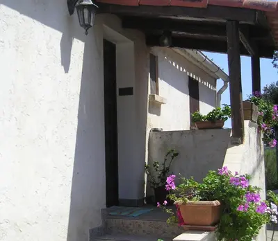 a white house with two potted plants on the porch at E Stelle di A Bella Vista in Bonifacio