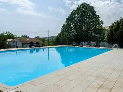 a large swimming pool with blue water and chairs at Holiday Home Cavoni by Interhome in Moriani Plage