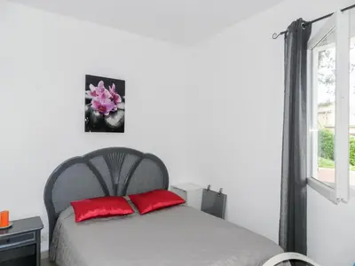 a bedroom with a bed with red pillows and a window at Holiday Home Cavoni by Interhome in Moriani Plage