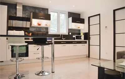 a kitchen with white cabinets and a black counter top at Nice Home In Ville Di Paraso With Wifi in Ville-di-Paraso