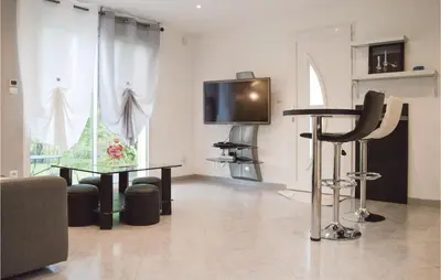 a living room with a table and a tv at Nice Home In Ville Di Paraso With Wifi in Ville-di-Paraso