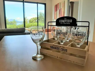 two wine glasses sitting on a table with a box at Camélia Plein Soleil Bord de Plage in Coti-Chiavari