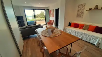 a living room with a table and a couch at Camélia Plein Soleil Bord de Plage in Coti-Chiavari
