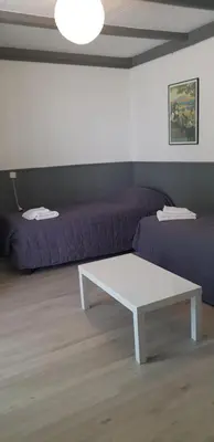 a room with two beds and a tiled floor at Bungalows Filippi in Porto-Vecchio