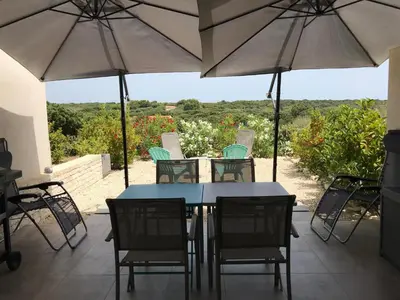 a table and chairs with umbrellas on a patio at Villa Louise in Bonifacio