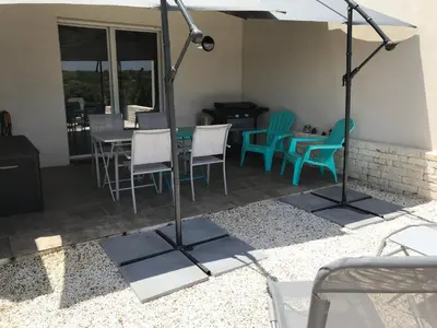a patio with a table and chairs and an umbrella at Villa Louise in Bonifacio