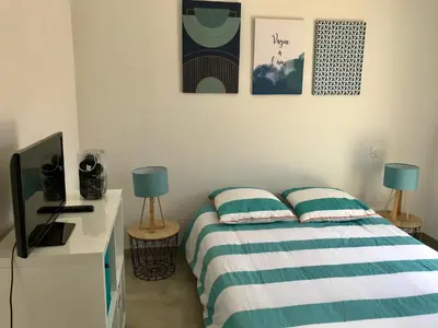 a bedroom with a bed and a desk with two lamps at Villa Louise in Bonifacio