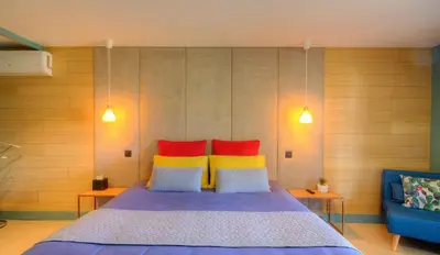 a bedroom with a bed with two red and yellow pillows at Au pied des oliviers in Calenzana