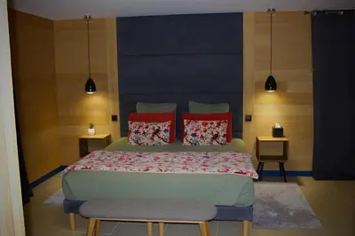 a bedroom with a large bed with red pillows at Au pied des oliviers in Calenzana