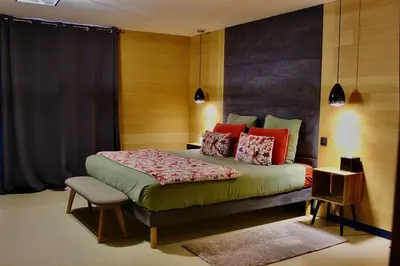 a bedroom with a bed with red pillows at Au pied des oliviers in Calenzana