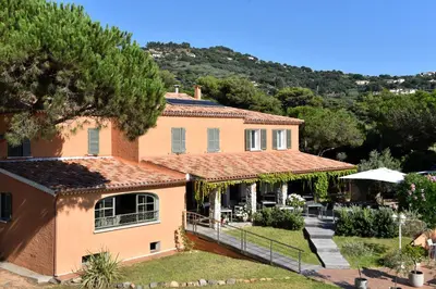 an image of a house with a hill in the background at Hôtel Les Lentisques in Cargèse