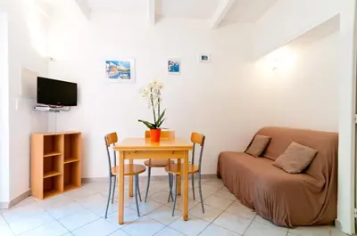 a living room with a table and a couch at Résidence Les Lièges de Palombaggia in Porto-Vecchio
