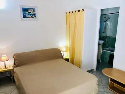 a small bedroom with a bed and a bathroom at Résidence Les Lièges de Palombaggia in Porto-Vecchio