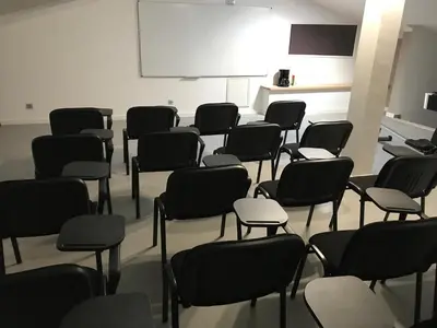 a classroom with black chairs and a white board at Casa di a Restonica in Corte