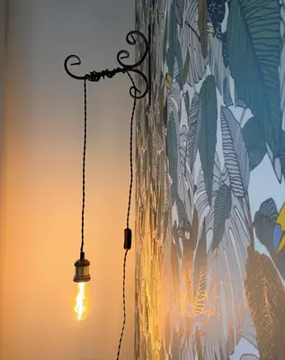 a light hanging from a wall with a painting at Hôtel confidentiel Le Grecale in Pianottoli-Caldarello