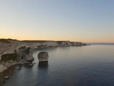 an aerial view of a beach with rocks in the water at chez dume in Bonifacio