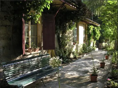 a bench sitting outside of a house with plants at Hotel Monte d'Oro in Vizzavona