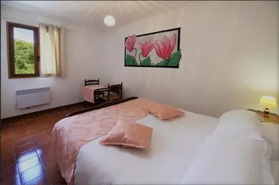 a bedroom with a bed with pink flowers on the wall at Hotel Monte d'Oro in Vizzavona
