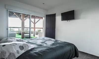 a bedroom with a bed and a flat screen tv at T2 vue sur le golfe d'Ajaccio in Porticcio