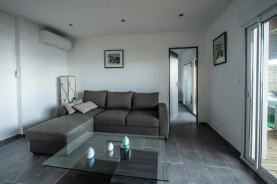 a living room with a couch and a glass table at T2 vue sur le golfe d'Ajaccio in Porticcio