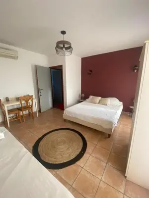 a bedroom with a bed and a table in it at Chez Dume in Santa-Lucia-di-Tallano