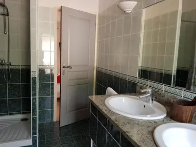 a bathroom with a sink and a mirror and a tub at Chez Dume in Santa-Lucia-di-Tallano