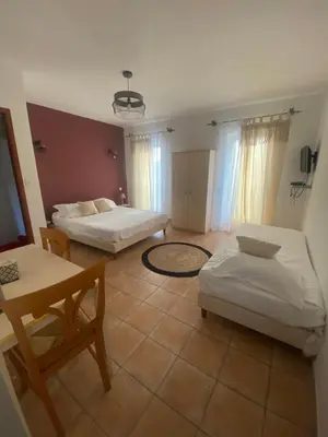 a living room with two beds and a table at Chez Dume in Santa-Lucia-di-Tallano