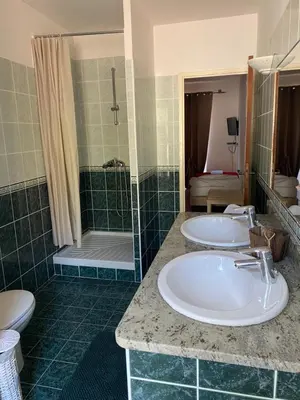 a bathroom with two sinks and a shower at Chez Dume in Santa-Lucia-di-Tallano