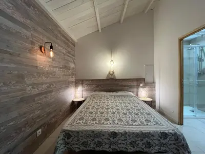 a bedroom with a bed and two lights on the wall at Le Maquis Plage Corse in Poggio-Mezzana