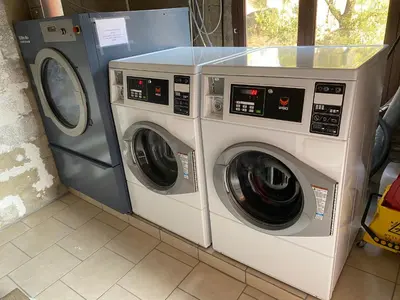 two washing machines and a washer and dryer in a room at Résidence Le Porto in Porto Ota