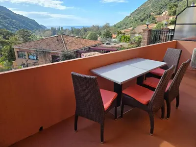 a table and chairs on a balcony with a view at Résidence Le Porto in Porto Ota