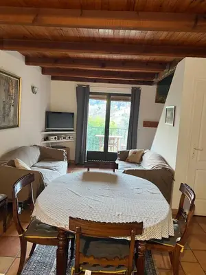 a living room with a table and a couch at Petite maison proche de la nature in Vico