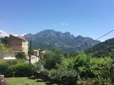a view of a mountain from a town at Petite maison proche de la nature in Vico