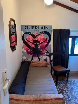 a bed in a room with a poster on the wall at Petite maison proche de la nature in Vico